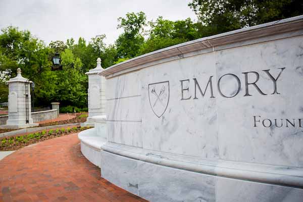 Emory logo carved on a marble wall beside Haygood-Hopkins Gate