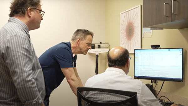 Three researchers viewing computer screen